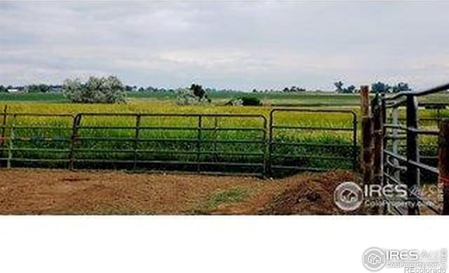 view of gate with fence and a rural view