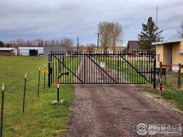 view of gate featuring fence and a lawn