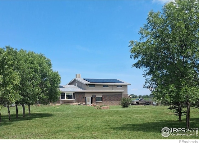 524 E County Road 8, Berthoud, CO 80513 - rear view of house featuring a yard, solar panels, and brick siding