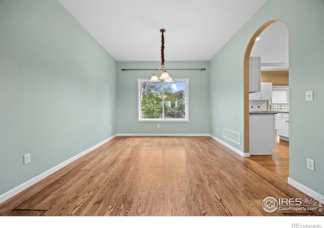 2275 Schooner St, Lafayette, CO 80026 - spare room with light wood finished floors, arched walkways, a chandelier, baseboards, and visible vents