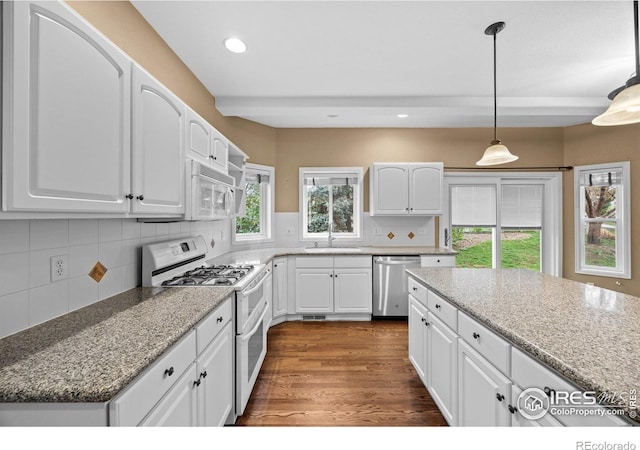 2275 Schooner St, Lafayette, CO 80026 - kitchen featuring tasteful backsplash, dark wood finished floors, a sink, white appliances, and white cabinetry