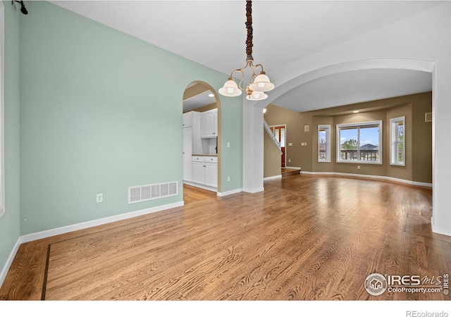 2275 Schooner St, Lafayette, CO 80026 - spare room with visible vents, arched walkways, light wood-style floors, and baseboards