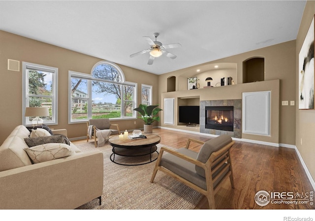 2275 Schooner St, Lafayette, CO 80026 - living area with a tiled fireplace, baseboards, a ceiling fan, and wood finished floors