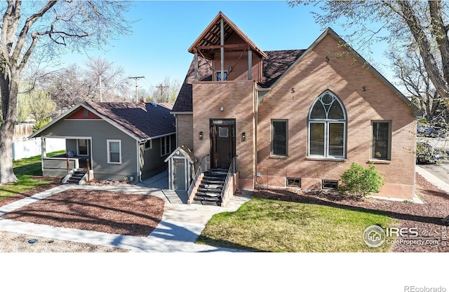 view of front facade with brick siding and a front yard
