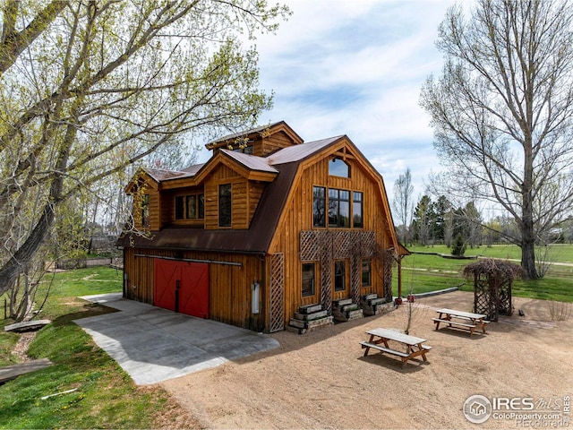 7929 Valmont Rd, Boulder, CO 80301 - view of front of house with a gambrel roof, dirt driveway, a garage, and a front yard