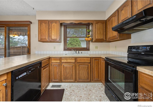 1183 38th Ave, Greeley, CO 80634 - kitchen featuring black appliances, ventilation hood, light countertops, brown cabinets, and plenty of natural light