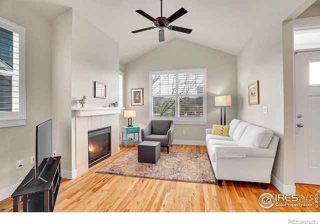 541 Hoyt Ln, Lafayette, CO 80026 - living area with wood finished floors, lofted ceiling, baseboards, ceiling fan, and a tile fireplace