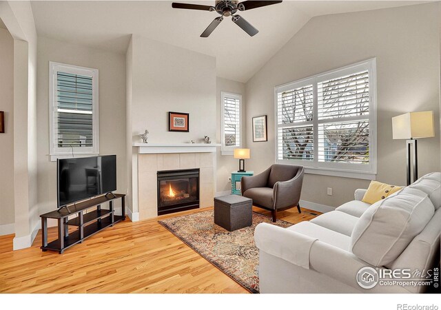 541 Hoyt Ln, Lafayette, CO 80026 - living room with ceiling fan, a tiled fireplace, vaulted ceiling, wood finished floors, and baseboards