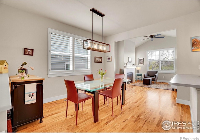 541 Hoyt Ln, Lafayette, CO 80026 - dining area featuring baseboards, vaulted ceiling, light wood-style flooring, and ceiling fan with notable chandelier