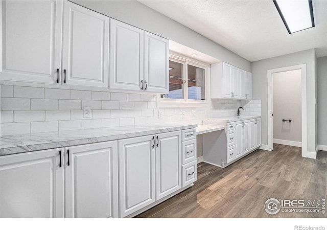 4121 Silene Pl, Loveland, CO 80537 - kitchen featuring tasteful backsplash, a sink, baseboards, white cabinets, and light wood-style flooring