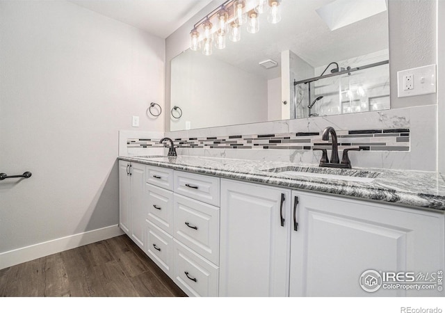 4121 Silene Pl, Loveland, CO 80537 - full bathroom with a sink, double vanity, a shower stall, wood finished floors, and tasteful backsplash