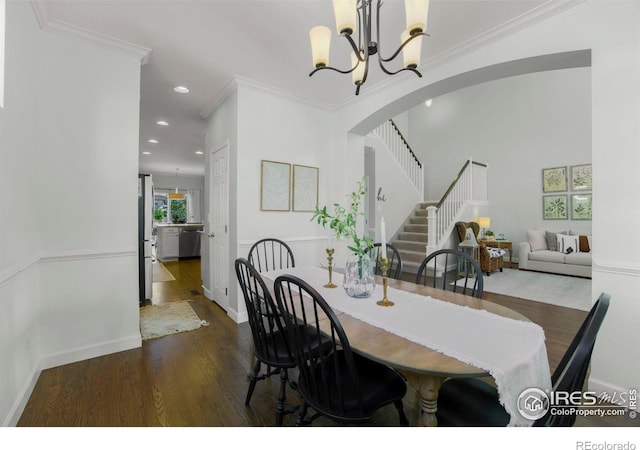 dining area featuring stairs, wood finished floors, recessed lighting, an inviting chandelier, and arched walkways