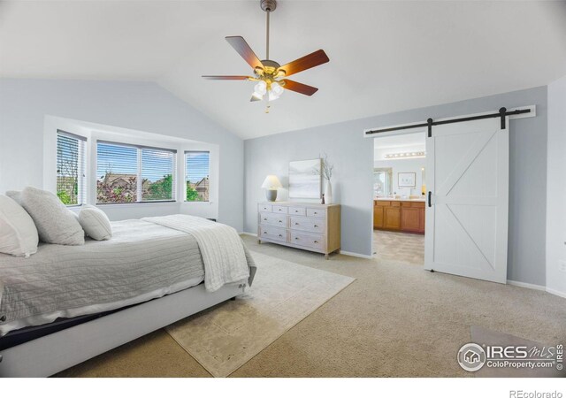 bedroom featuring light colored carpet, a barn door, vaulted ceiling, connected bathroom, and baseboards