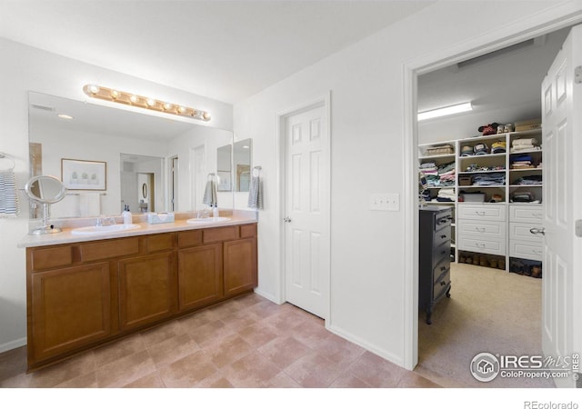 full bathroom with a spacious closet, double vanity, and a sink