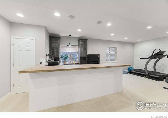 kitchen featuring decorative light fixtures, butcher block countertops, light carpet, and recessed lighting