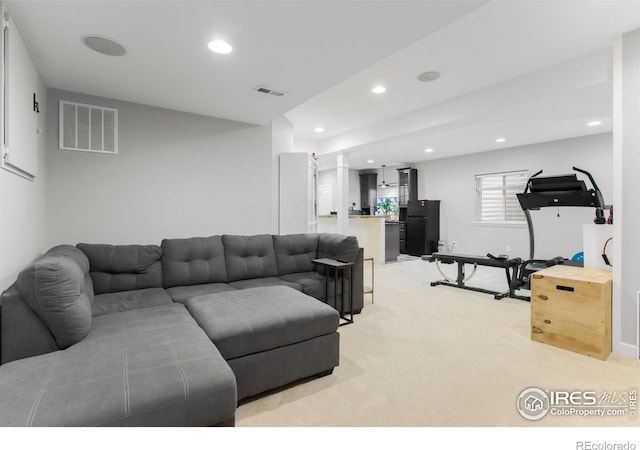 living area featuring light carpet, visible vents, and recessed lighting