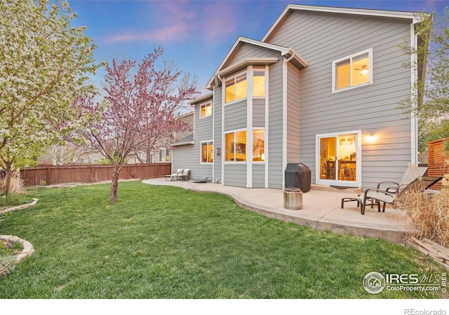 back of property featuring a patio, fence, and a lawn