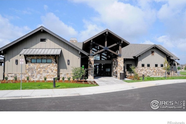 6386 Mayfair Ave, Timnath, CO 80547 - view of front facade with board and batten siding, stone siding, a chimney, and roof with shingles