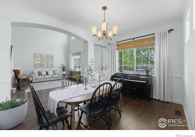 6386 Mayfair Ave, Timnath, CO 80547 - dining area with arched walkways, wood finished floors, plenty of natural light, a chandelier, and crown molding