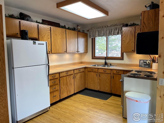 134 Swift Deer Rd, Red Feather Lakes, CO 80545 - kitchen featuring freestanding refrigerator, a sink, stove, light wood-style floors, and light countertops