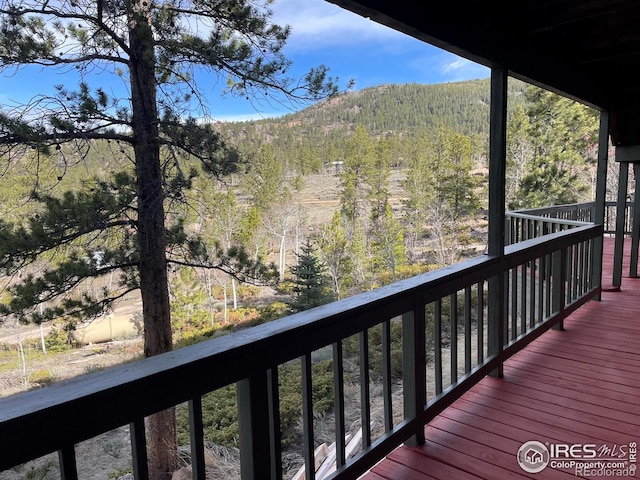 134 Swift Deer Rd, Red Feather Lakes, CO 80545 - wooden terrace with a mountain view and a wooded view