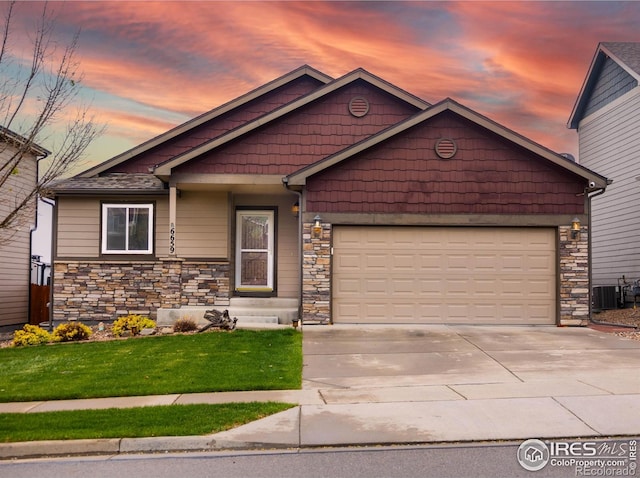6659 12th St, Frederick, CO 80530 - view of front of property featuring driveway, a garage, central air condition unit, a front lawn, and stone siding