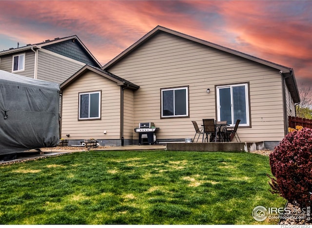 6659 12th St, Frederick, CO 80530 - back of house at dusk with a lawn and a patio