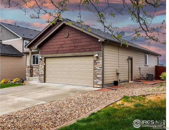 6659 12th St, Frederick, CO 80530 - exterior space with concrete driveway, central AC unit, stone siding, and a garage