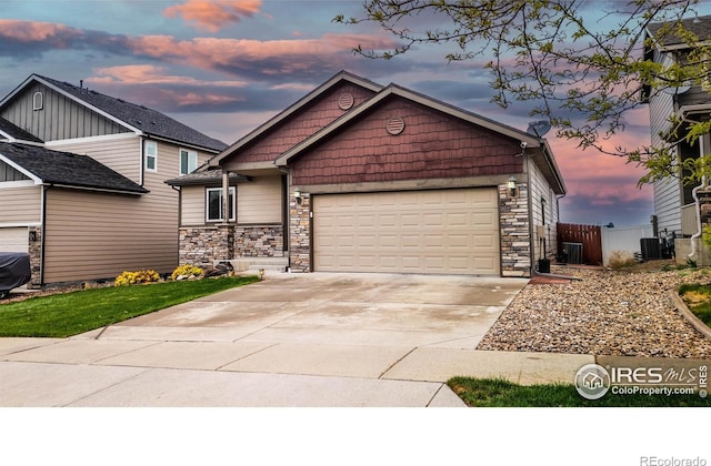 6659 12th St, Frederick, CO 80530 - view of front of property with fence, stone siding, a garage, concrete driveway, and central air condition unit