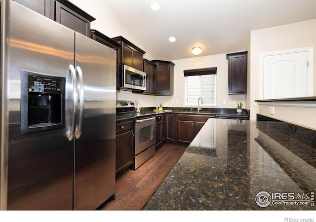 6659 12th St, Frederick, CO 80530 - kitchen with dark brown cabinetry, dark wood-style floors, a sink, dark stone countertops, and stainless steel appliances