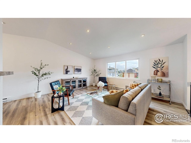 living area with baseboards, light wood finished floors, lofted ceiling, and baseboard heating