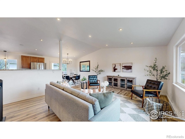 living room featuring a chandelier, baseboards, light wood finished floors, lofted ceiling, and recessed lighting