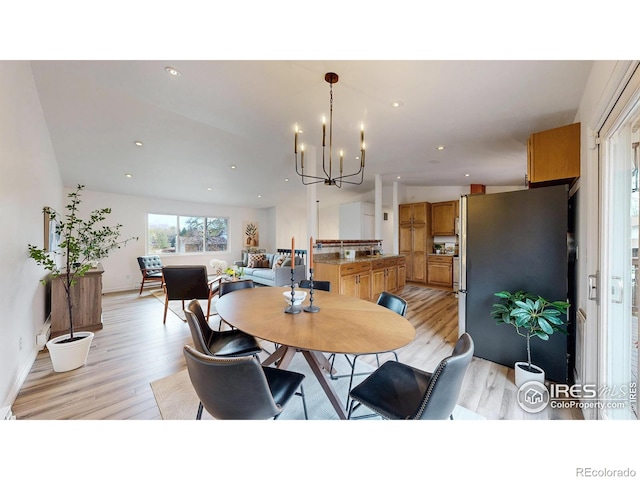 dining space with baseboards, recessed lighting, light wood-style flooring, and a chandelier