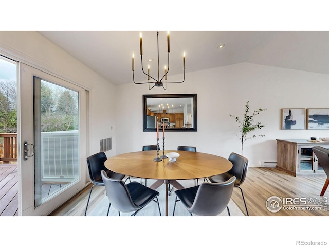 dining space with visible vents, baseboards, baseboard heating, light wood finished floors, and a notable chandelier