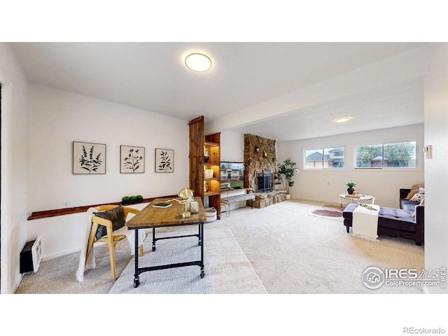 office space with baseboards, a stone fireplace, and carpet