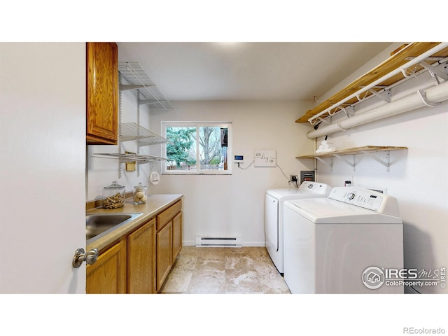 laundry area with baseboards, a baseboard heating unit, washing machine and clothes dryer, a sink, and cabinet space