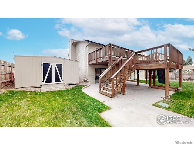 rear view of property with a shed, a yard, a wooden deck, and fence
