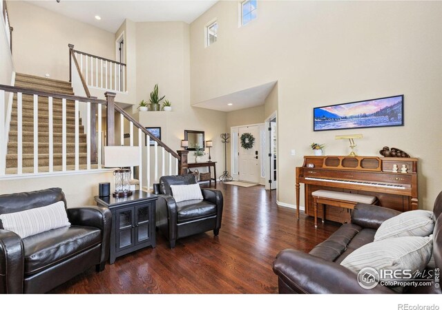 living area featuring recessed lighting, stairs, a towering ceiling, and wood finished floors