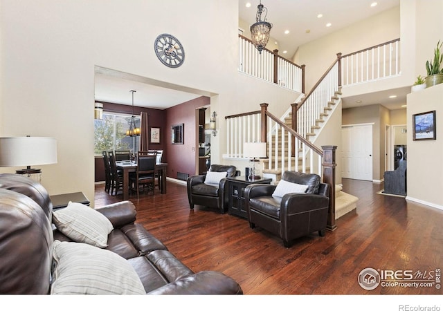 living area with stairs, wood finished floors, a chandelier, a high ceiling, and recessed lighting