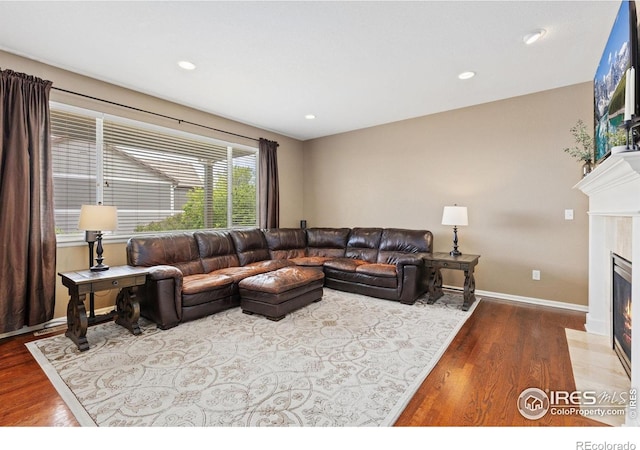 living room with a fireplace with flush hearth, baseboards, recessed lighting, and wood finished floors
