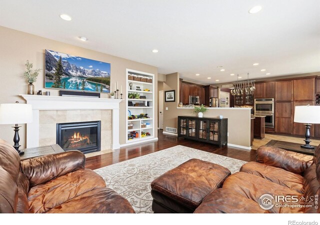 living area with recessed lighting, dark wood-style floors, a fireplace, and visible vents