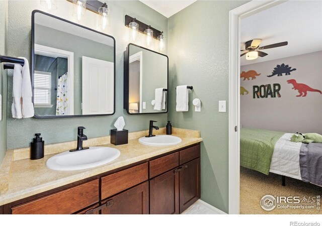 full bath featuring double vanity, a ceiling fan, a sink, and ensuite bathroom