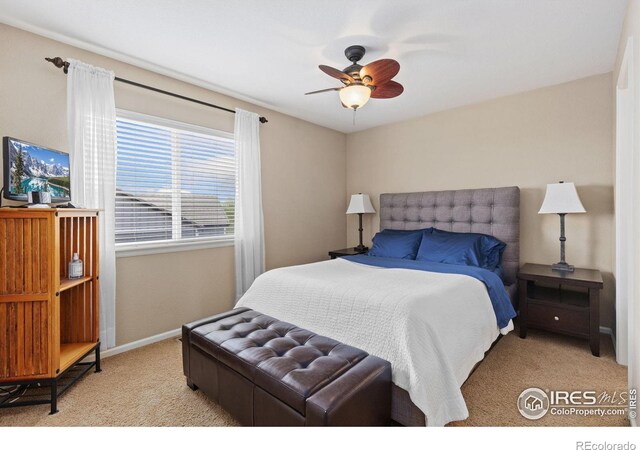 bedroom with light colored carpet, baseboards, and ceiling fan