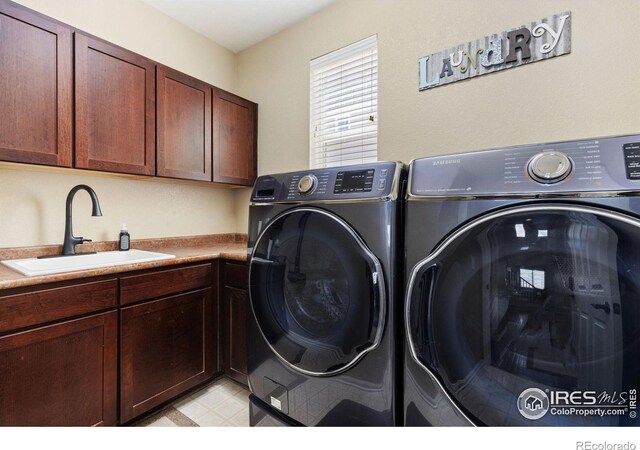 washroom featuring light floors, a sink, cabinet space, and independent washer and dryer