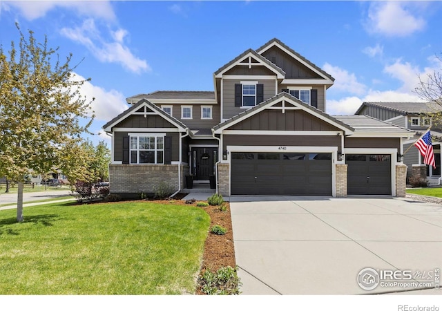 craftsman-style house featuring board and batten siding, concrete driveway, a front lawn, and brick siding