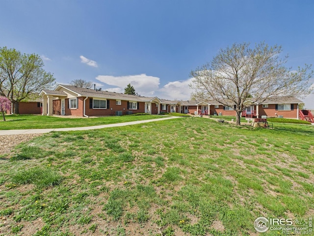 5425 County Road 32 Unit 15, Mead, CO 80504 - view of front of property with a front yard, brick siding, and central air condition unit