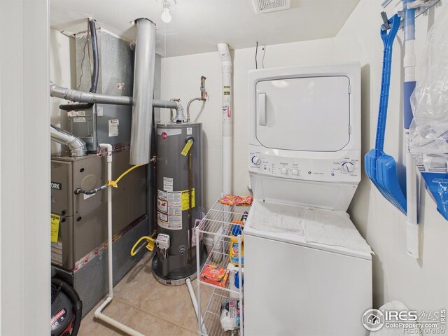 5425 County Road 32 Unit 15, Mead, CO 80504 - washroom with stacked washing machine and dryer, water heater, heating unit, and tile patterned flooring