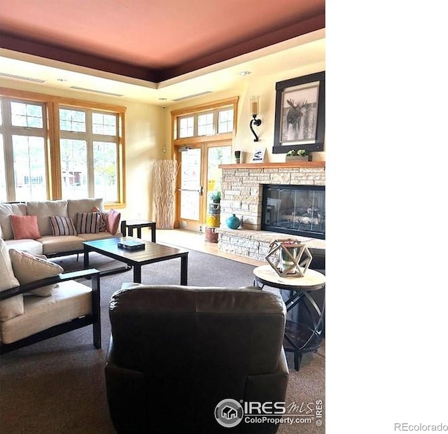 13873 Legend Way Unit 103, Broomfield, CO 80023 - carpeted living area with a tray ceiling, healthy amount of natural light, and a fireplace