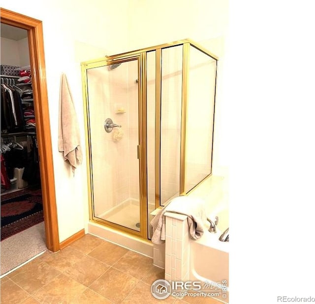 13873 Legend Way Unit 103, Broomfield, CO 80023 - bathroom featuring a stall shower, a walk in closet, and a garden tub