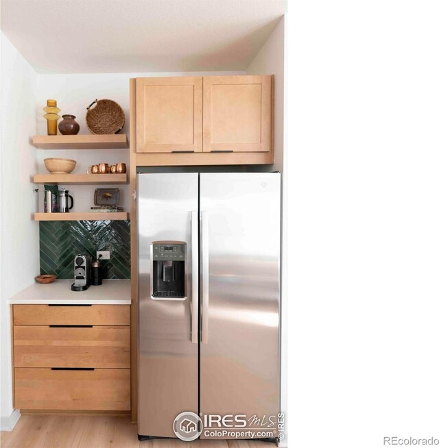 4424 Haymill Ct, Timnath, CO 80547 - kitchen with stainless steel fridge with ice dispenser, light brown cabinetry, open shelves, light wood finished floors, and light countertops
